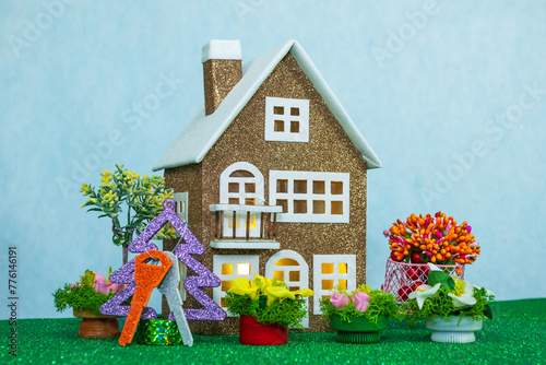 Brown house with keys on the Christmas tree and many flowers around