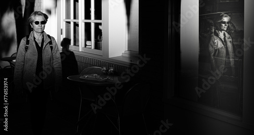 Window reflection of  senior woman walking