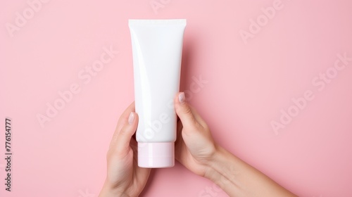Hand holding empty white cosmetic cream tube © JH45