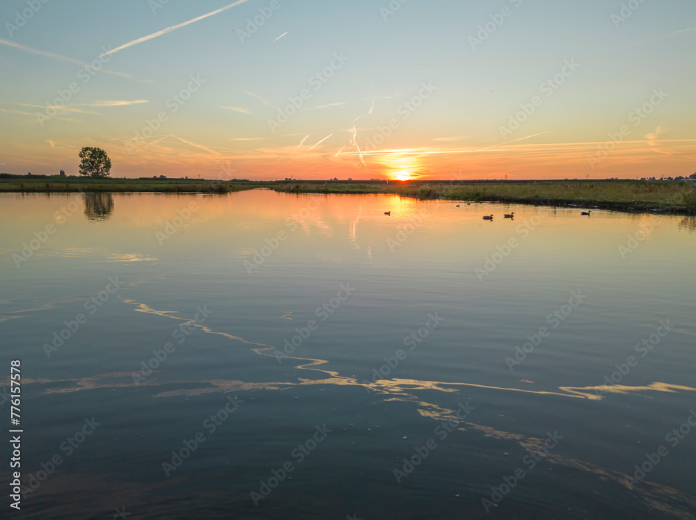 Sunset above the lake and nature area.
