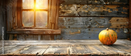   A pumpkin rests on a worn wooden table, bathed in sunlight filtering through the window panes © Jevjenijs