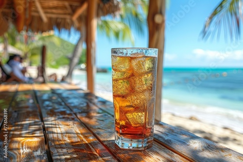 Cold cola in a glass with ice cubes, a perfect refreshing drink for a sunny beach day