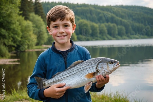 Portrait of 8-9 year old person holding a fish at a lake