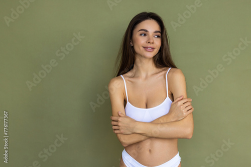 Young woman posing in comfortable cotton underwear isolated over green studio background.
