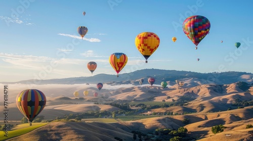 A cluster of colorful hot air balloons drifting lazily across a clear blue sky, painting a whimsical scene against the backdrop of rolling hills.