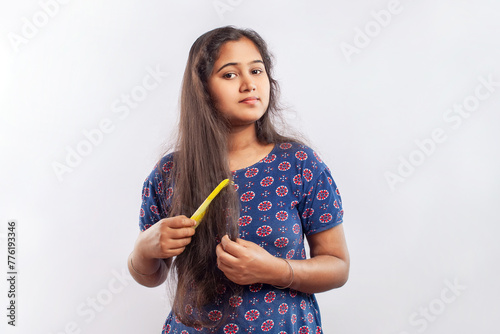indian women combing frizzy long hair in white background