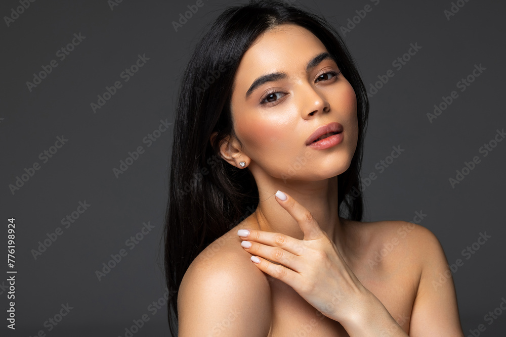 Portrait of attractive woman washing face moisturizing isolated over grey pastel color background