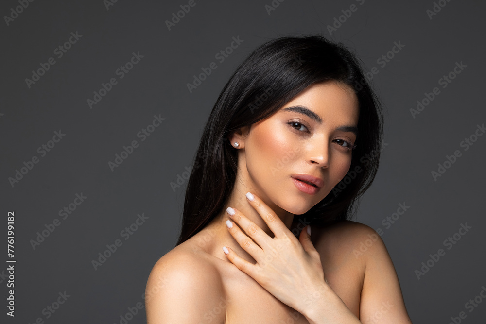 Fototapeta premium Close-up of an attractive woman wearing turtleneck sweater while sitting at isolated dark background.