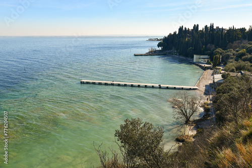 Elevated view of the Blondes Beach (Lido delle Bionde in Italian) with a wooden pier on Lake Garda, in winter, Sirmione, Brescia, Lombardy, Italy