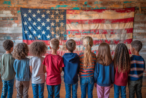 Group of school children standing in front of a large American flag, proudly reciting the Pledge of Allegiance to honor Flag Day