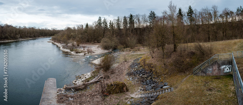 Panoramaaufnahme einer primitiven Holzhütte am Wasser gebaut aus Treibholz und Moos direkt unter Staumauer