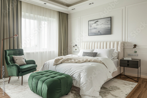White bedroom with kale green armchair  pouf and double bed.