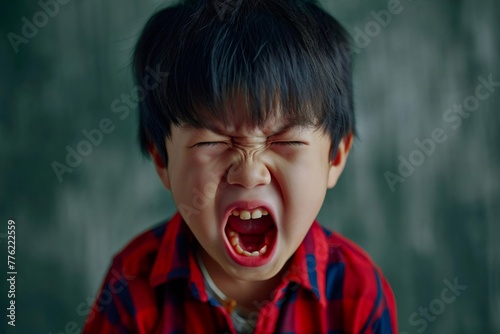 Portrait of Asian angry, sad and cry little boy on dirty grey color background, The emotion of a child when tantrum and mad, expression grumpy emotion, yelling, shouting. Kid emotional control concept