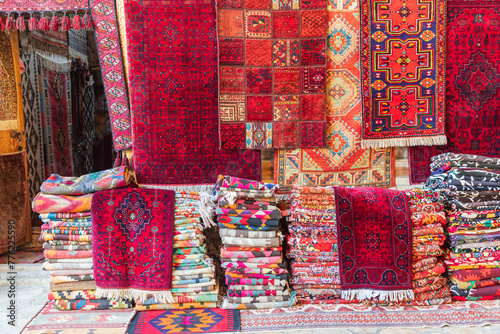 Rugs stacked and hanging outside a store in Bukhara.