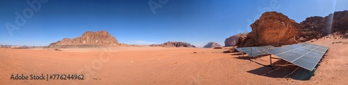 solar power plant in Wadi Rum desert in Jordan,Arabia, red sand dunes and rocky mountains in the background,renewable energy production technology solar panels,Arabia-Middle east