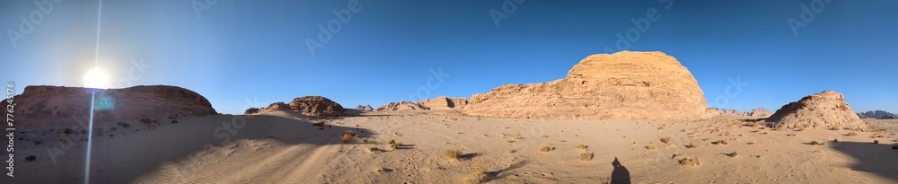 Panoramic view of Wadi Rum desert in Jordan with clouds moving over flat sand landscape with mountains and rocks formations.Discover beauty of the earth. National park outdoors landscape.UNESCO