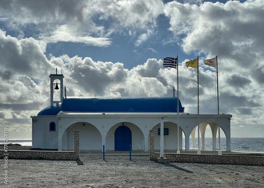Die Ayia Thekla Kapelle mit wehenden Fahnen am Meer bei Ayia Napa, Zypern - obrazy, fototapety, plakaty 