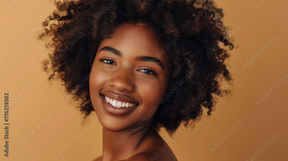 A woman with curly hair is smiling and looking at the camera. She has a natural, relaxed expression on her face A woman with curly hair is smiling and looking at the camera. She has a natural, relaxed expression on her face