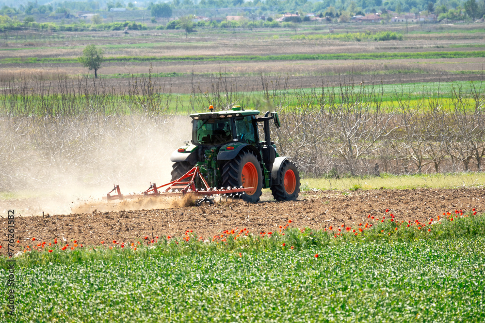 Fototapeta premium rear view of tractor preparing the fields for cultivation