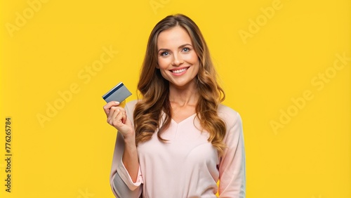 woman holding a card, woman isolated on yellow background holding credit card