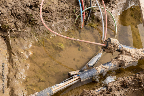 Disrupted during construction or repair work fiber optic cables for the internet lying in a trench.