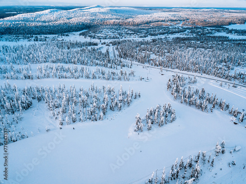 Aerial view of snow winter landscape with mountains, snow covered forests, frozen lakes and winter roads in Finland