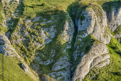 Massive rock formation covered with green fresh moss in Ciucas Mountains. Scenic landscapes in Carpathian Mountains, Romania.