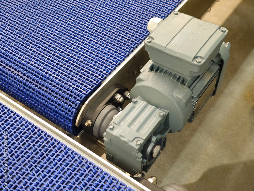 Electric motors in the stainless steel conveyor system with polyurethane, modular belt. Transport systems in industrial factories.