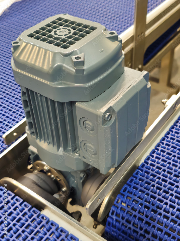 Electric motors in the stainless steel conveyor system with polyurethane, modular belt. Transport systems in industrial factories.