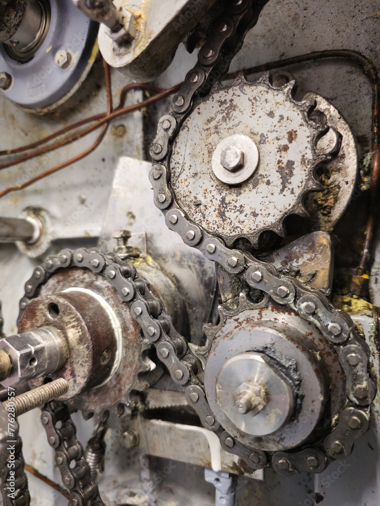 Sprockets and drive chain in an old industrial machine. Keeping machines in full working condition