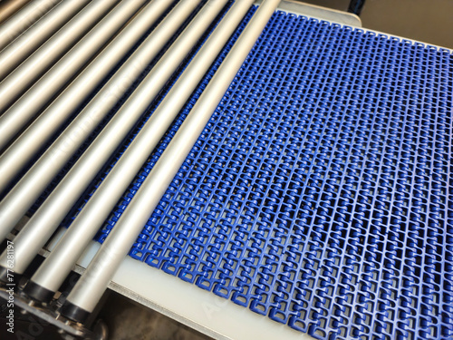 Obraz na płótnie A close-up of a blue polyurethane belt in modular industrial conveyor system connected with roller conveyor. Transport systems in industrial factories. w salonie