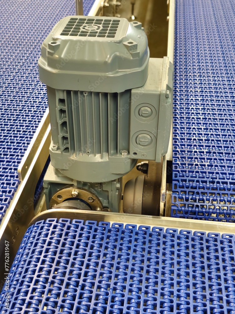 Electric motors in the stainless steel conveyor system with polyurethane, modular belt. Transport systems in industrial factories.