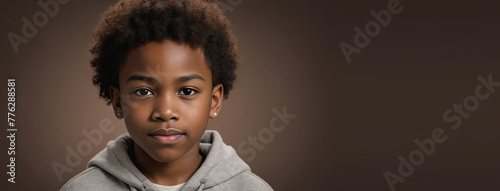 An African American Juvenile Boy, Isolated On A Brown Background With Copy Space photo