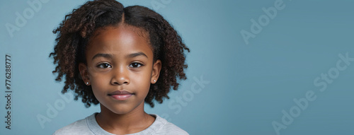 10-12 Years African American Juvenile Girl, Isolated On A Light Blue Background With Copy Space photo