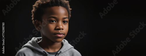 An African American Juvenile Boy, Isolated On A Black Background With Copy Space photo