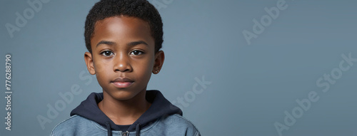 An African American Juvenile Boy, Isolated On A Grey-Blue Background With Copy Space photo
