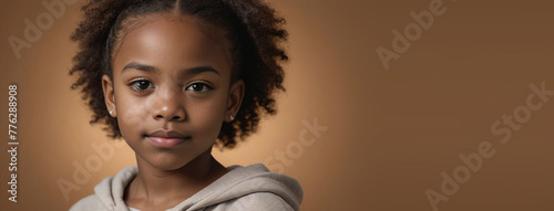 An African American Youngster Girl, Isolated On A Amber Background With Copy Space photo
