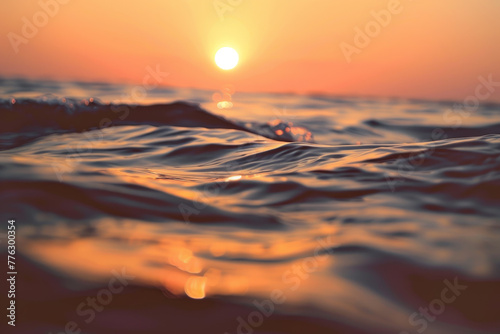 The sun is setting over the ocean, casting a warm glow on the water © Formoney
