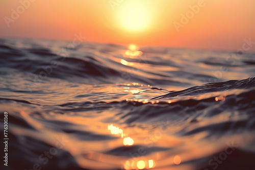 The sun is setting over the ocean, casting a warm glow on the water