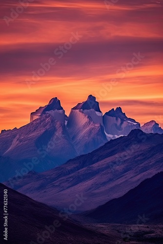 Silhouette of jagged mountain peaks with the sky painted in shades of orange, pink and purple colors, © neirfy