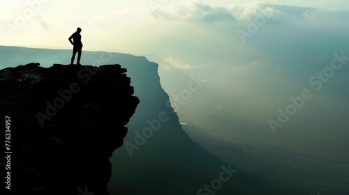 man on the mountaintop with steep rocks and white clouds