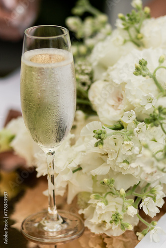 a glass of champagne on the registration table and a wedding bouquet