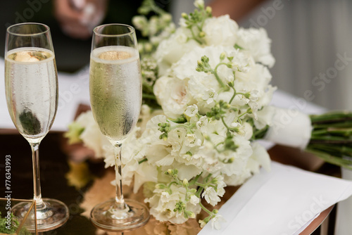 a glass of champagne on the registration table and a wedding bouquet