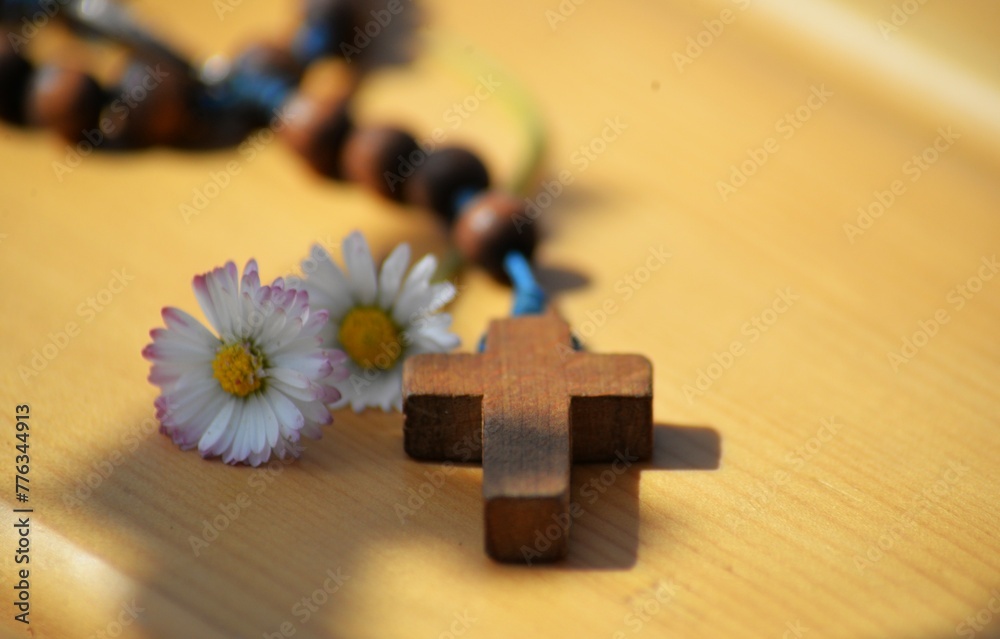 Wooden rosary on the table and daisy flower religious background Wooden rosary on the table and daisy flower religious background
