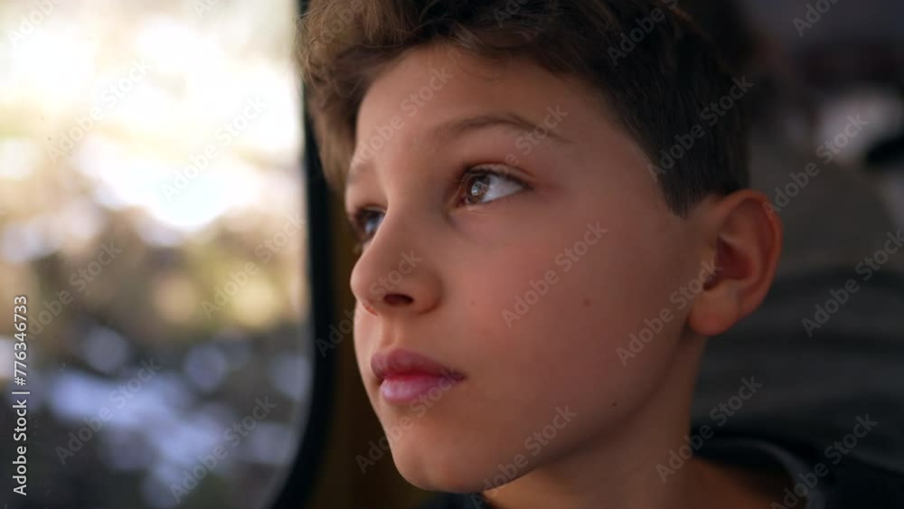 Thoughtful young boy during train trip looking at landscape scenery pass by, close-up face of pre-teen child in contemplative gaze Thoughtful young boy during train trip looking at landscape scenery pass by, close-up face of pre-teen child in contemplative gaze