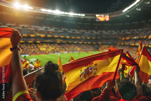 A group of people cheering and waving spanish flags on a football match in a stadium