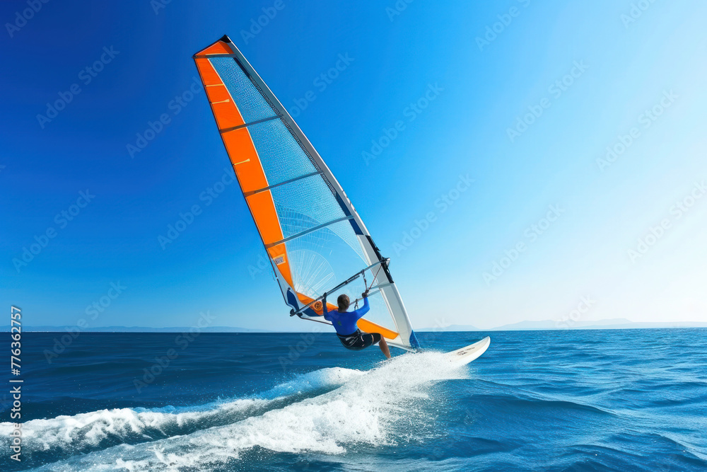 Naklejka premium Windsurfer in dynamic action, against clear blue sky