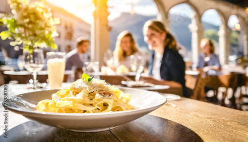 Fettuccine Alfredo, im Hintergrunde in Restaurant mit Gästen 