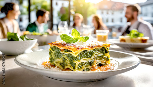 Lasagne mit Spinat im Hintergrund ein Restaurant mit Gästen  © Sina Ettmer