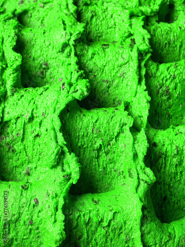 Frozen Cannabis flavour gelato - full frame detail of sorbet. Close up of a green surface texture of Ice cream filled with pieces of mixed fruits.